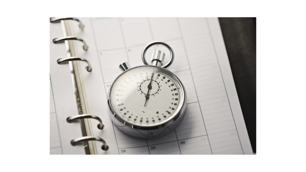 スケジュール帳の上に置かれた時計の写真