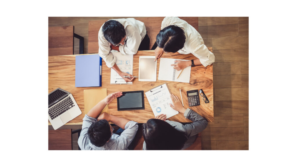 四人で集まり表やグラフを検討している場面の写真